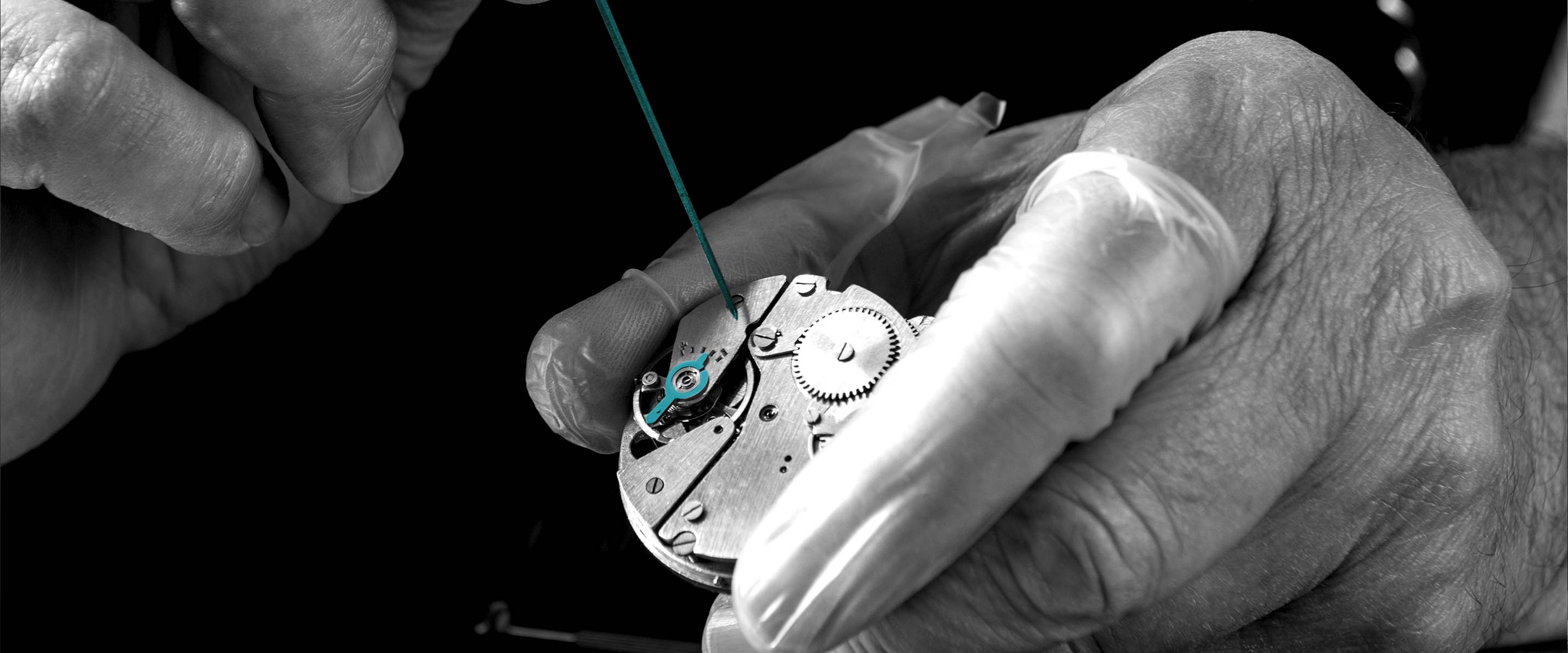 Nahaufnahme eines Uhrwerks in händischer Bearbeitung. Teile des Werks und Schraubenzieher in petrol hervorgehoben